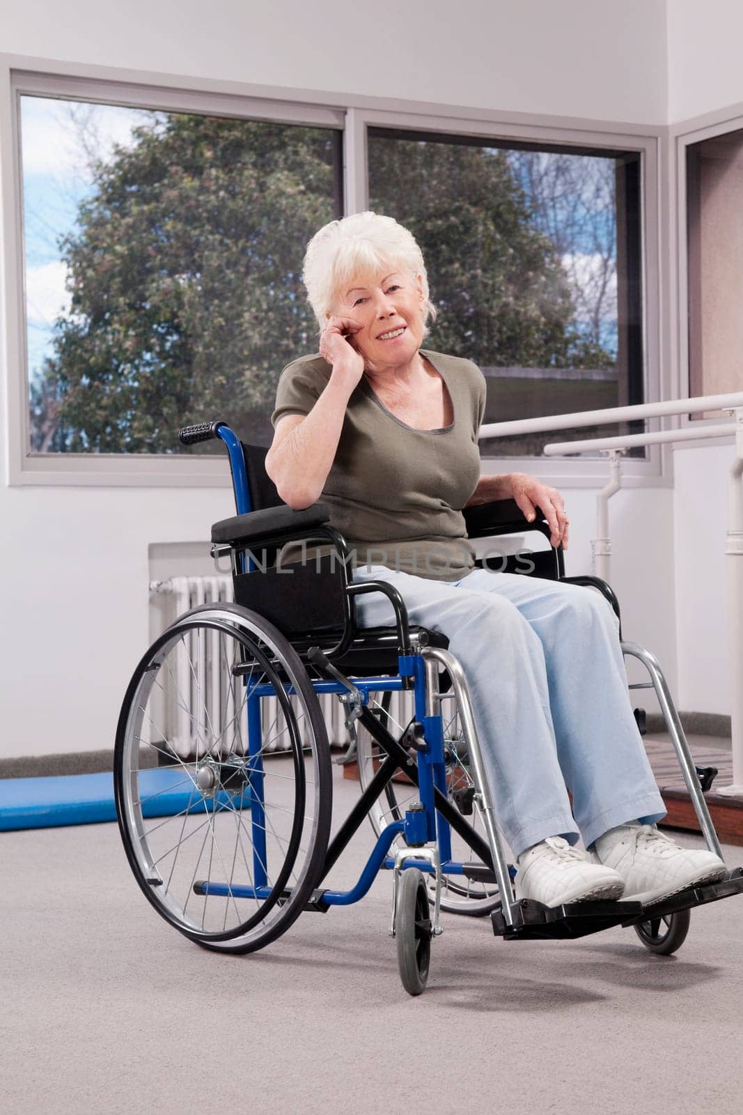 Disabled woman sitting in a wheelchair and talking on a mobile phone