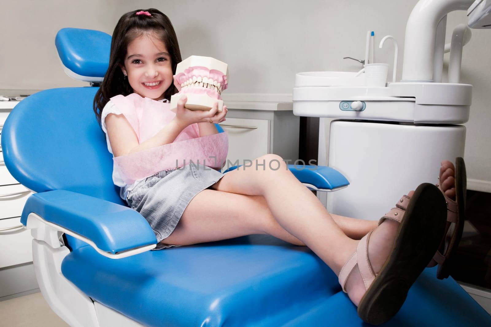 Portrait of a girl holding a set of dentures