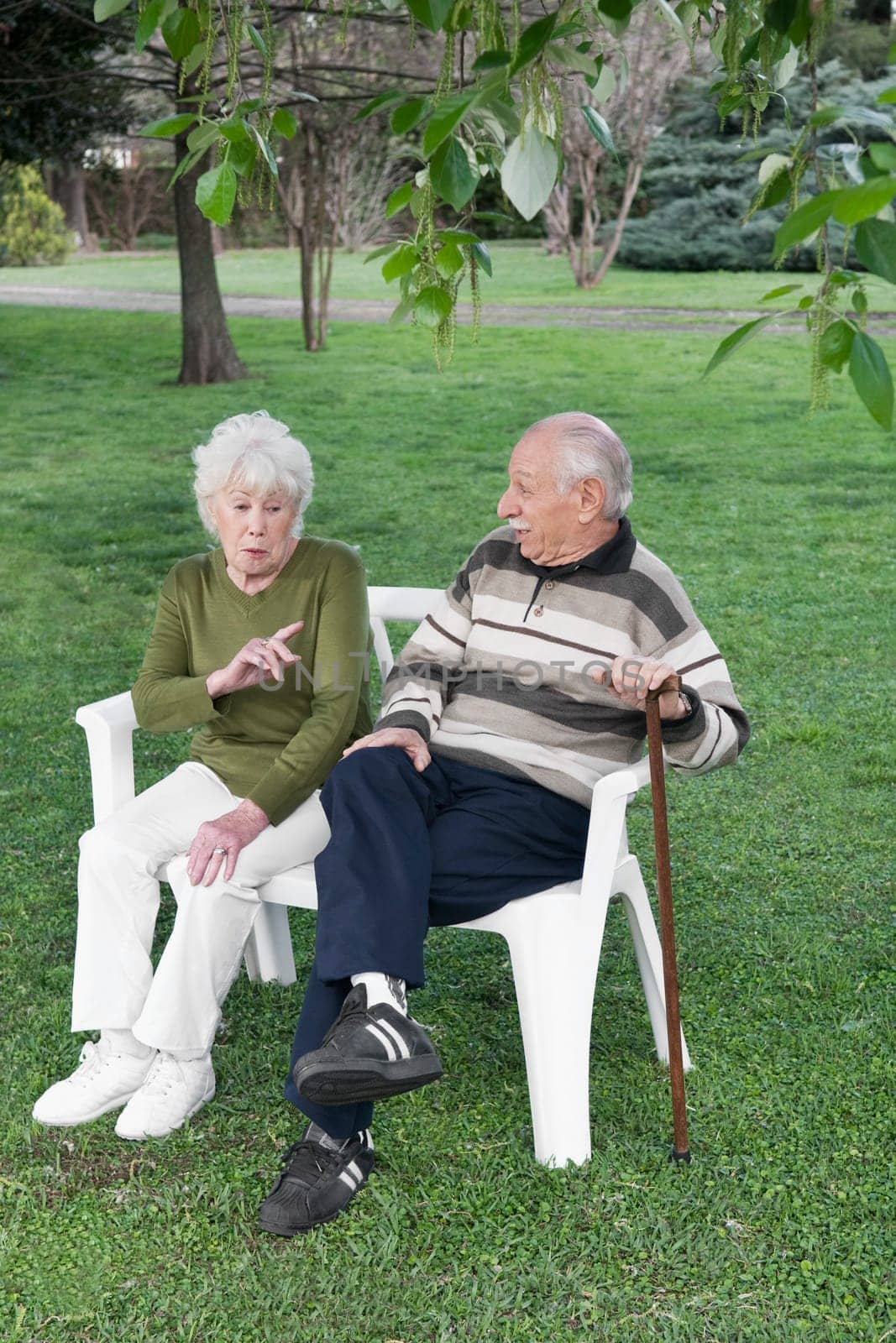 Couple sitting on chairs in a park