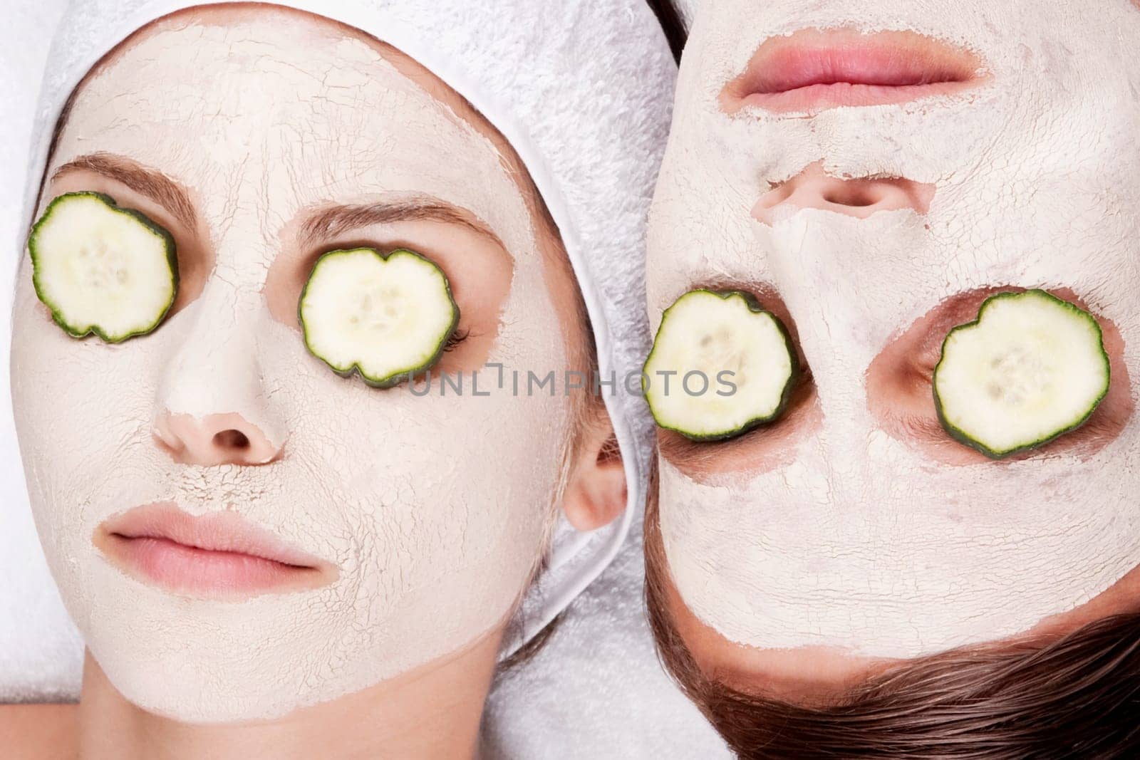 Couple with face pack and cucumber slices on their eyes