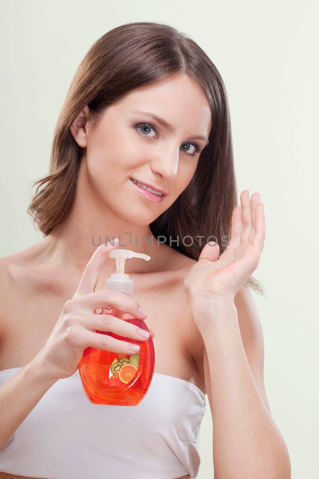 Portrait of a woman holding a bottle of liquid soap