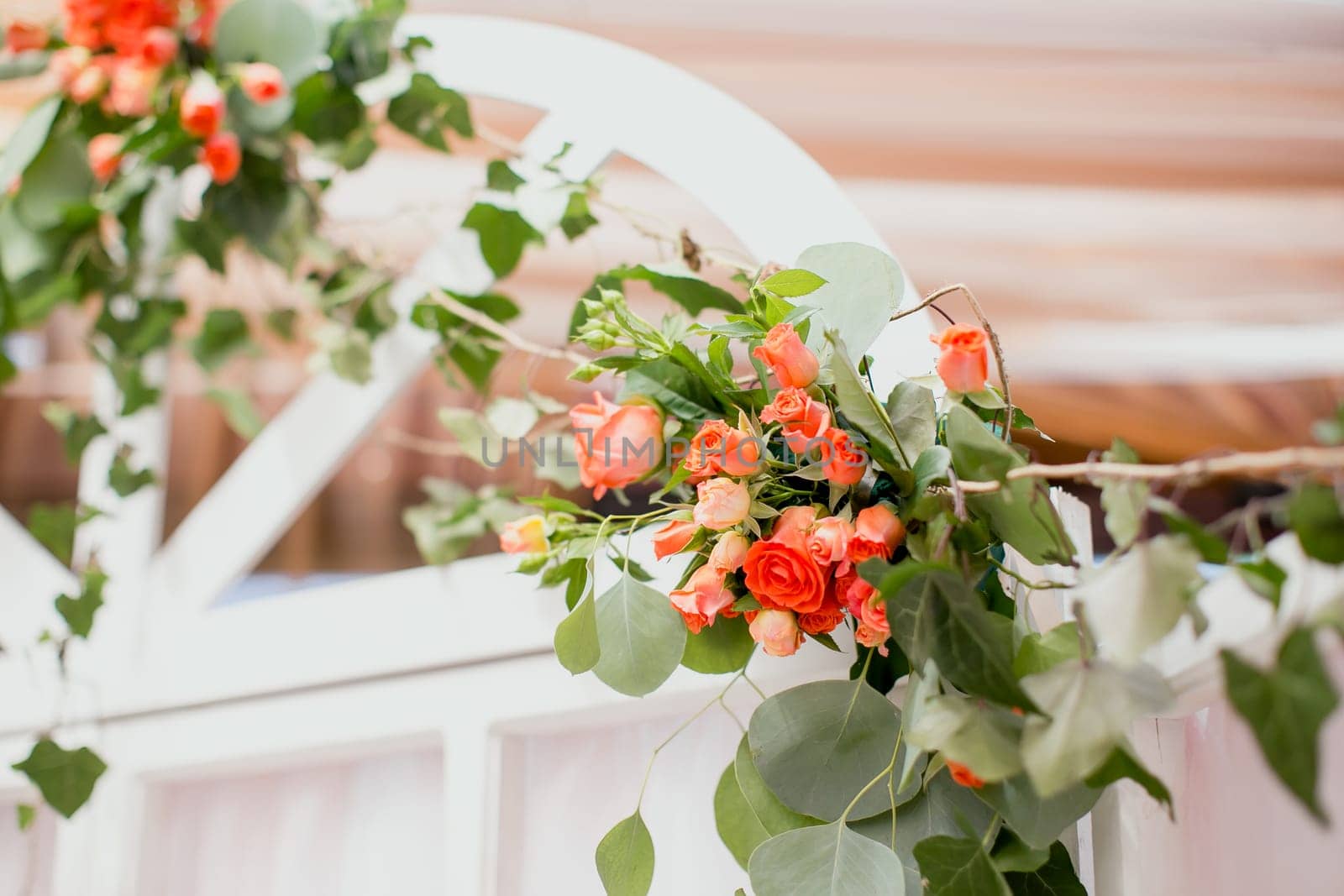Wedding decorations. White arch with rose flowers. Blurred background. High quality photo