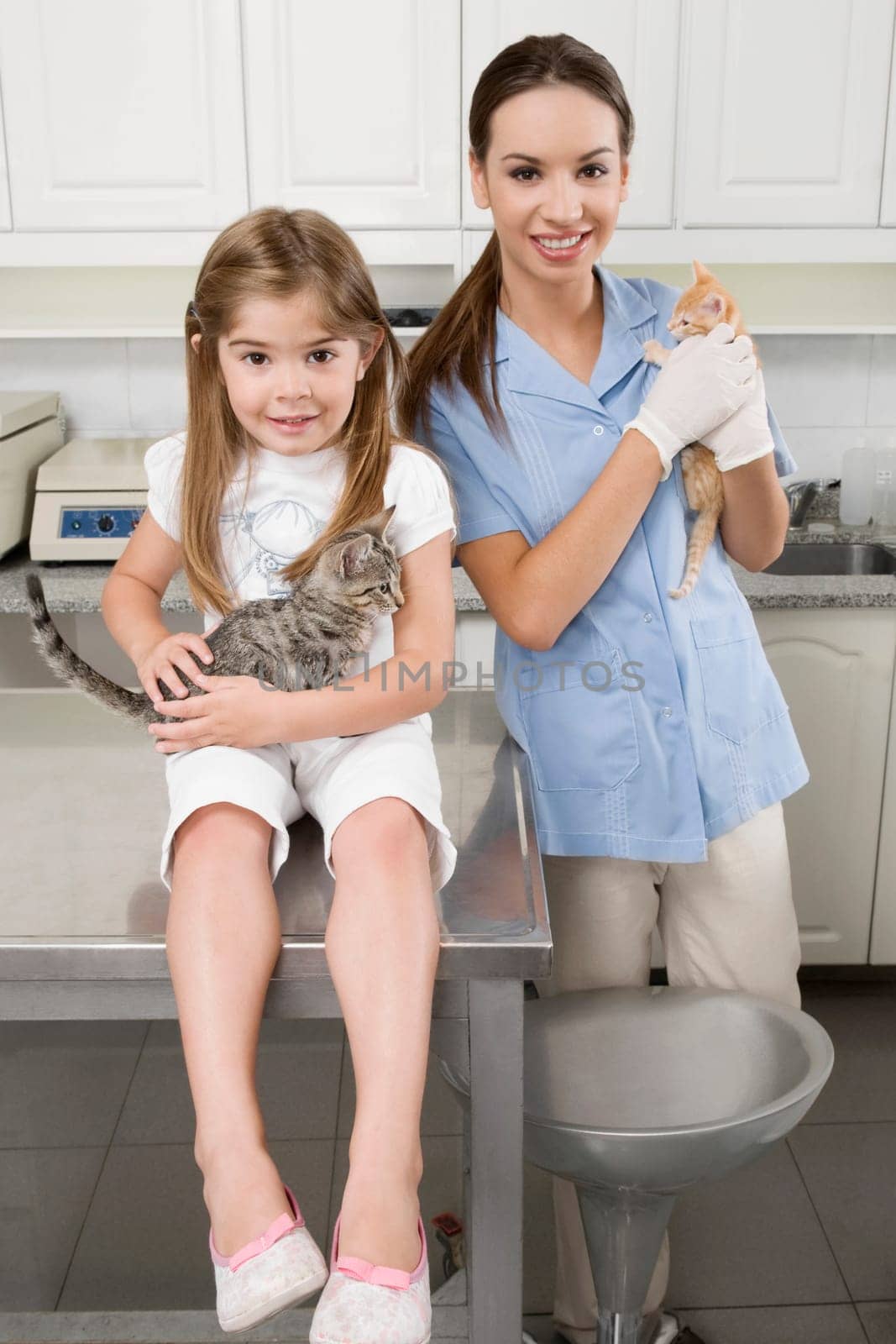Female vet with a girl carrying cats