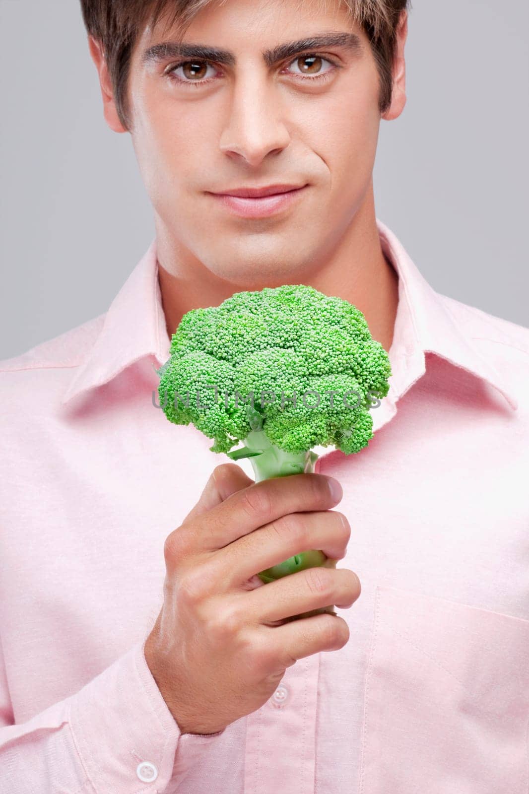Portrait of a man holding a broccoli