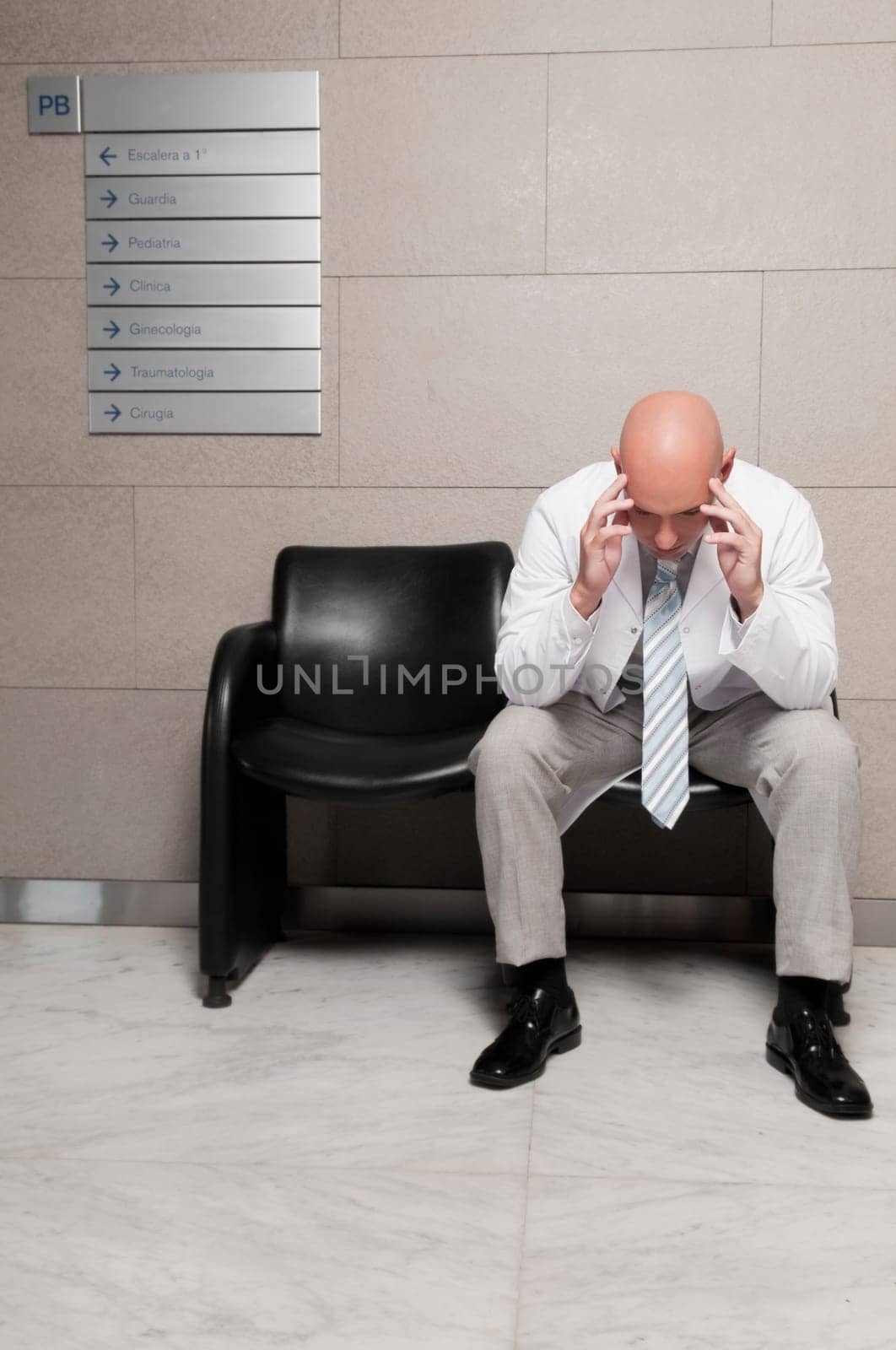 Doctor sitting on a chair and looking stressed