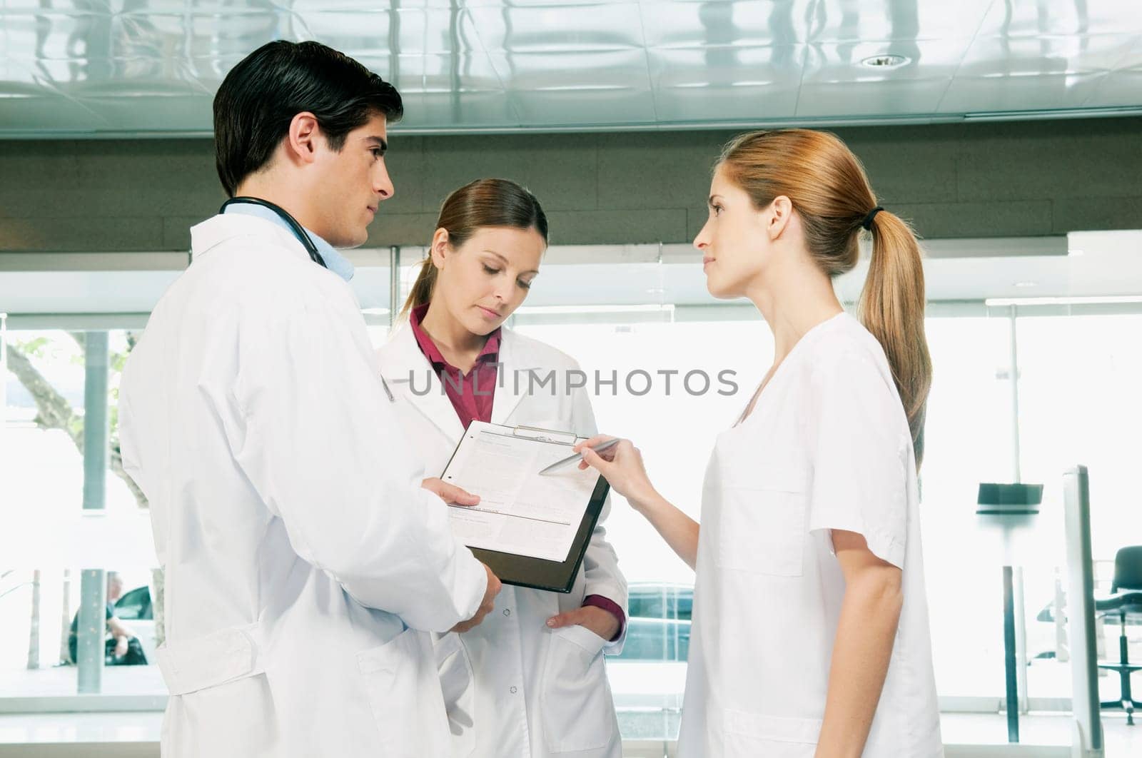 Three doctors discussing a report