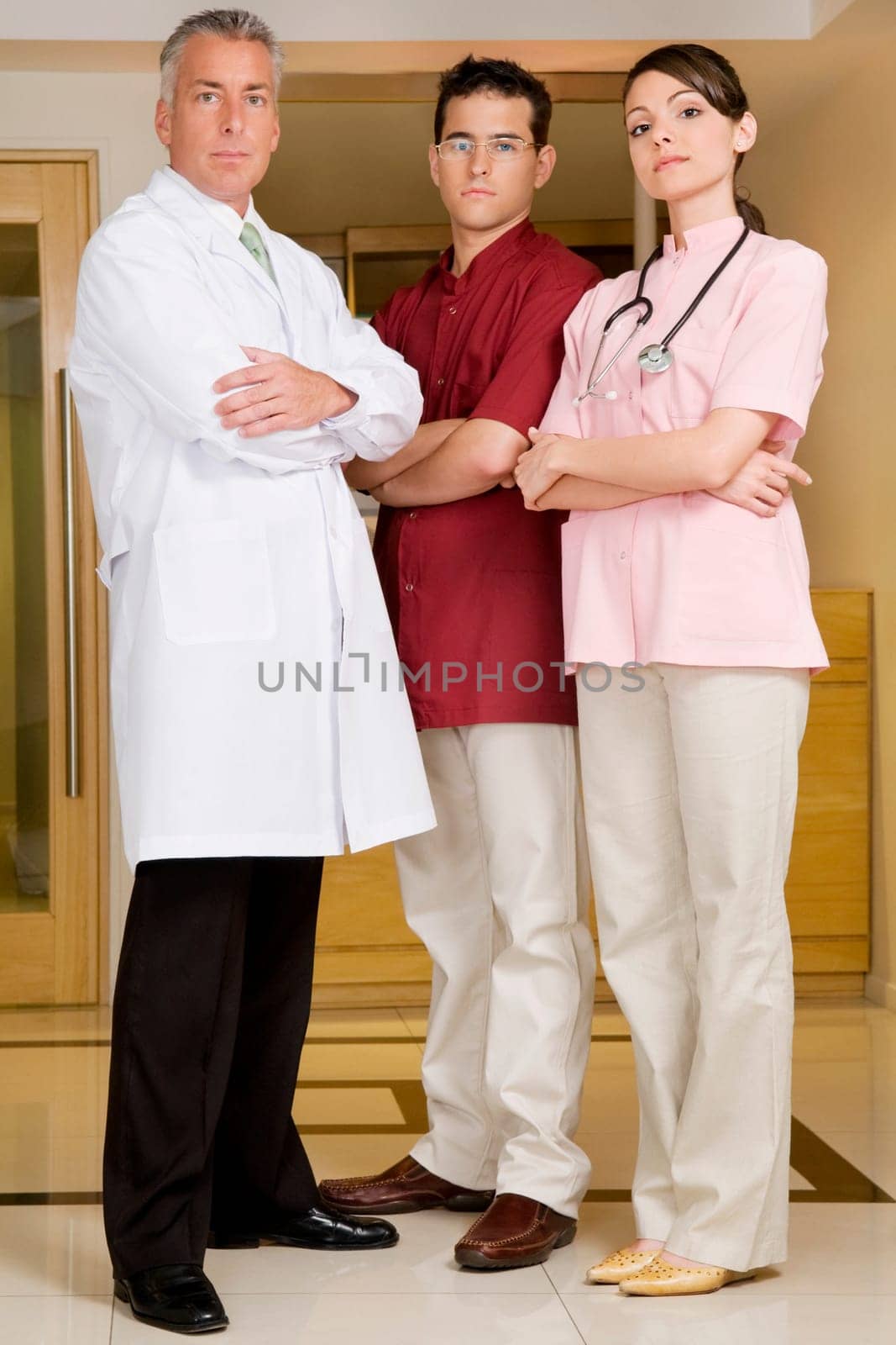 Portrait of a female doctor standing with two male doctors