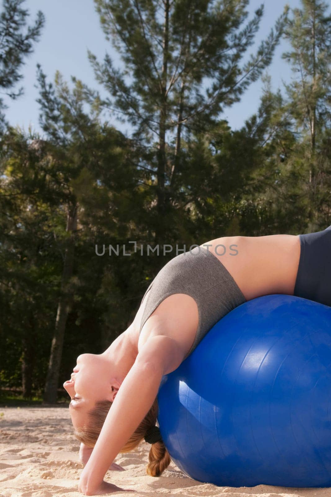 Woman exercising with a fitness ball on the beach
