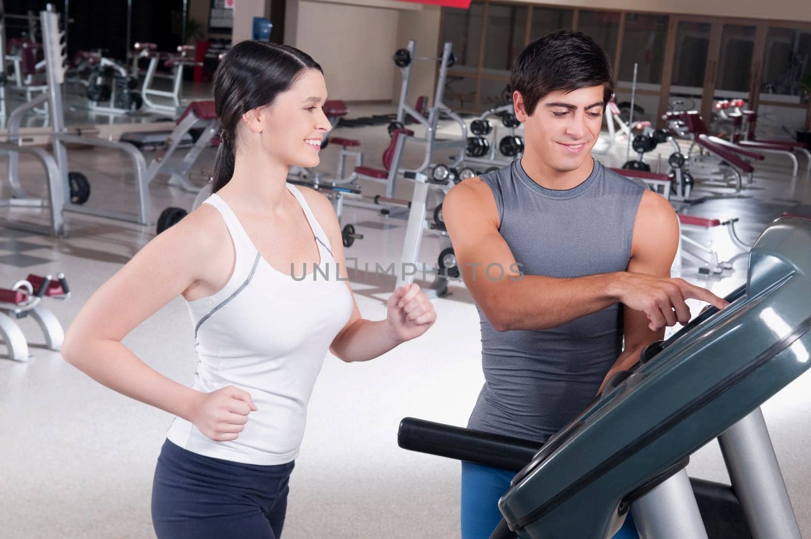 Man assisting a woman on a treadmill