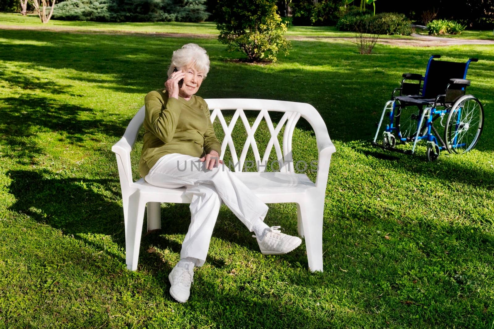 Woman sitting in a park and using a mobile phone