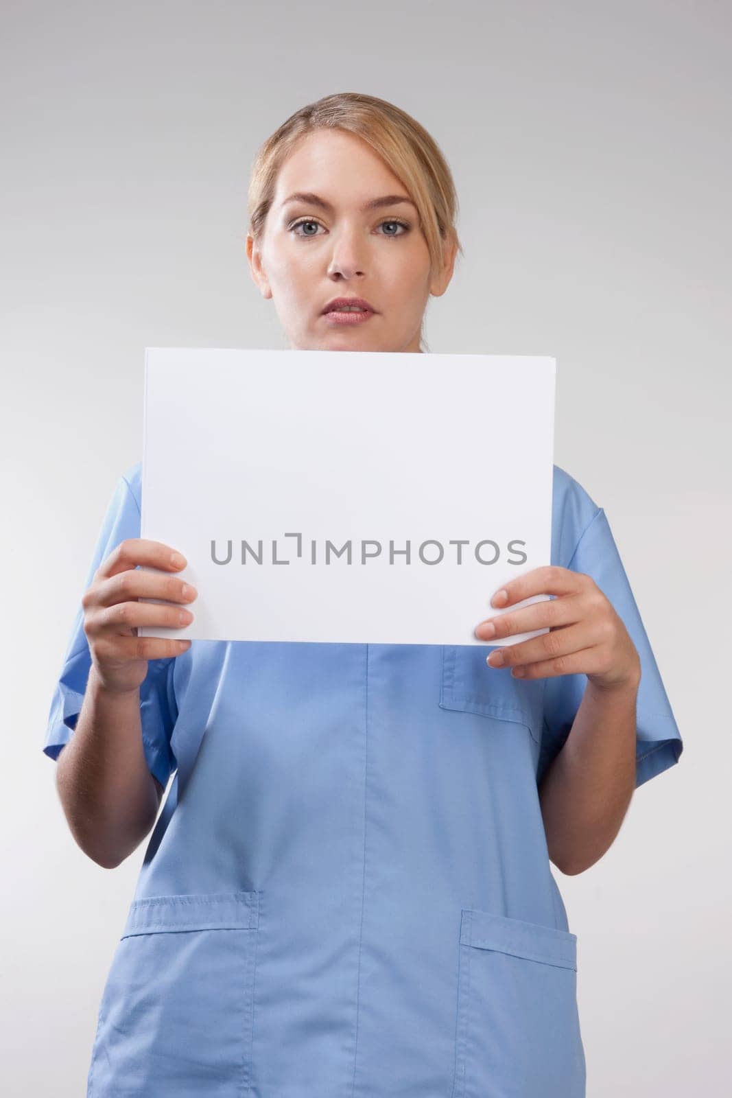 Female nurse holding blank placard