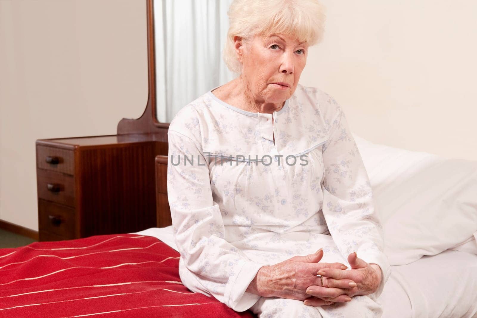 Woman sitting on the bed and looking serious