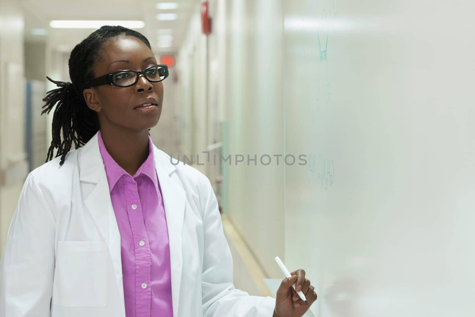 Female doctor writing on a whiteboard in a hospital
