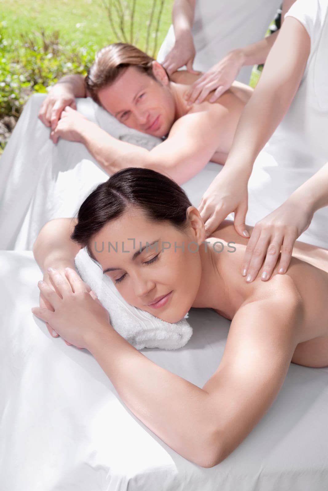 Couple receiving back massage from massage therapists