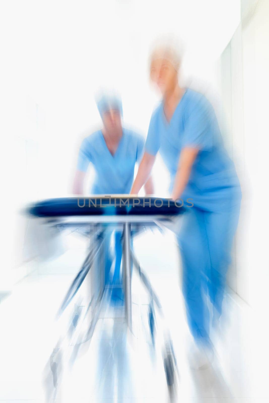 Two doctors pushing a gurney in a hospital corridor