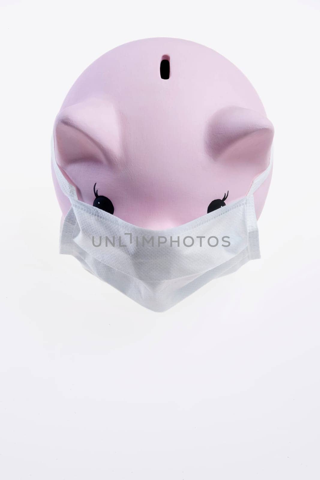 Close_up of a piggy bank wearing flu mask