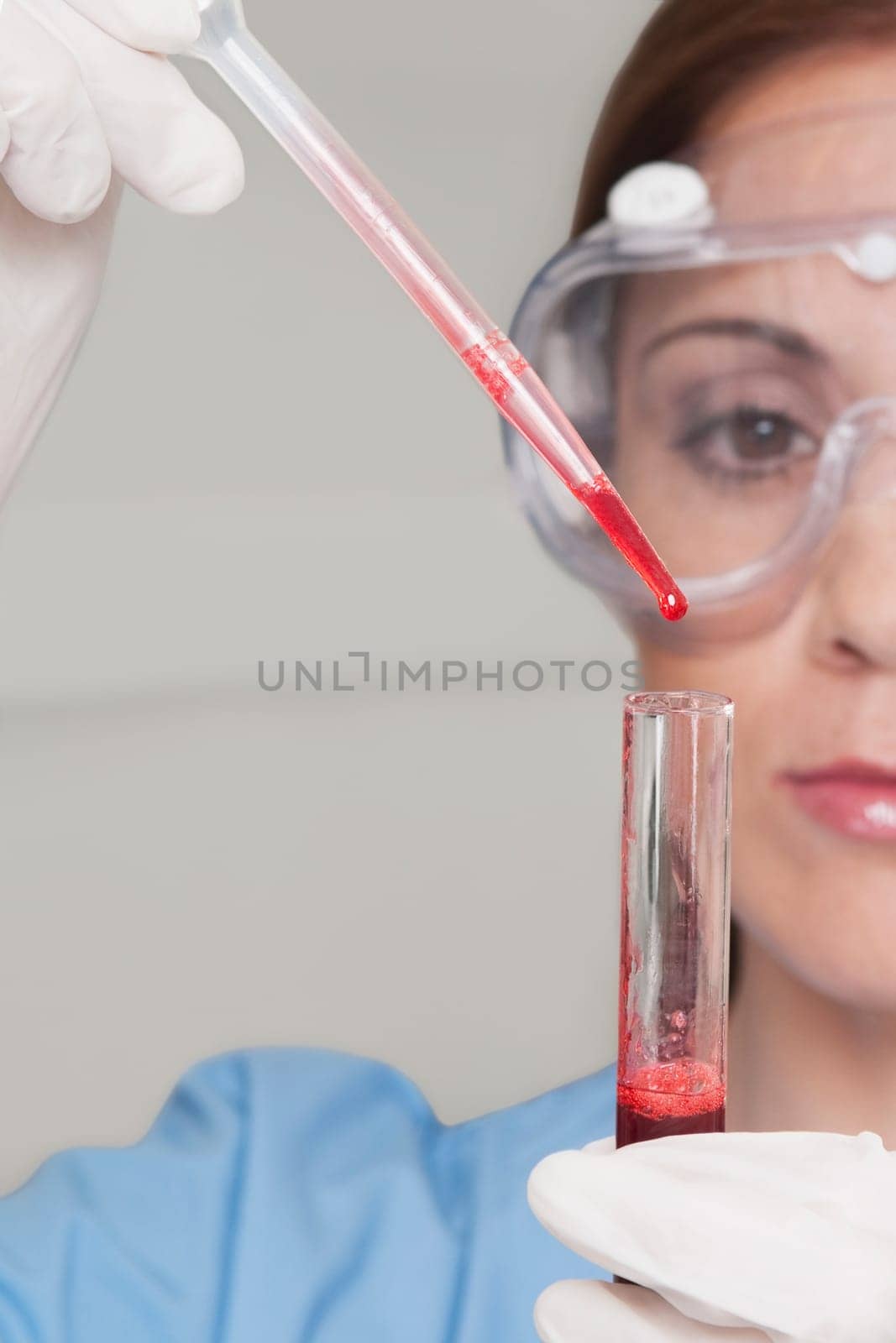 Female lab technician analyzing a blood sample in a test tube