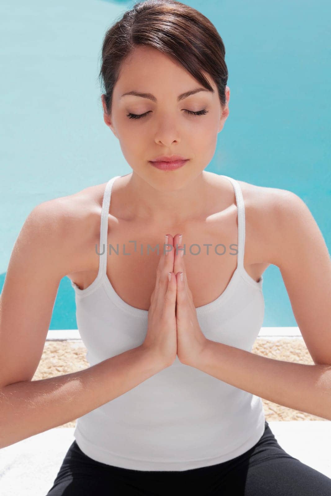 Woman practicing yoga at the poolside