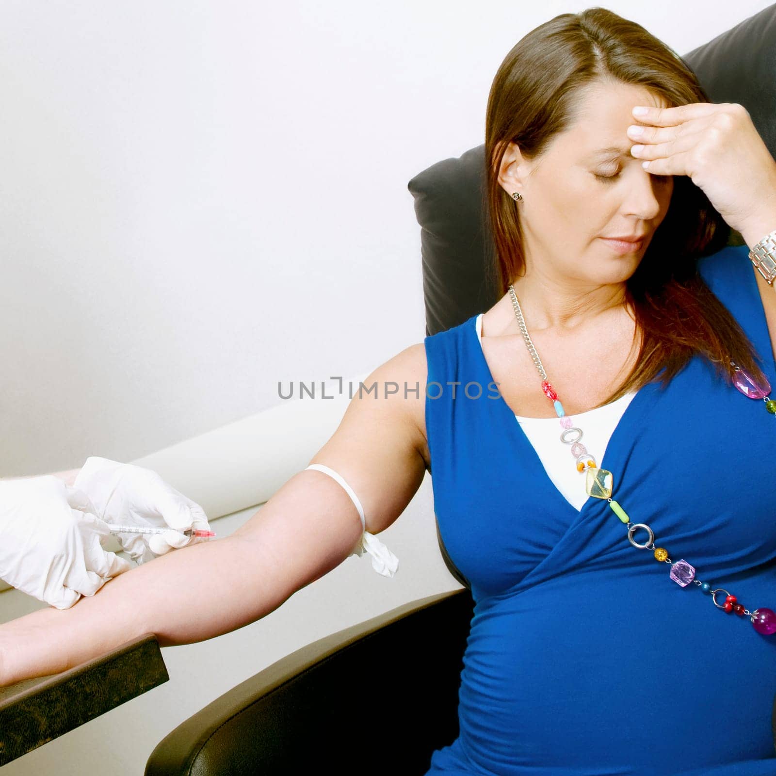 Doctor taking blood sample of a pregnant woman
