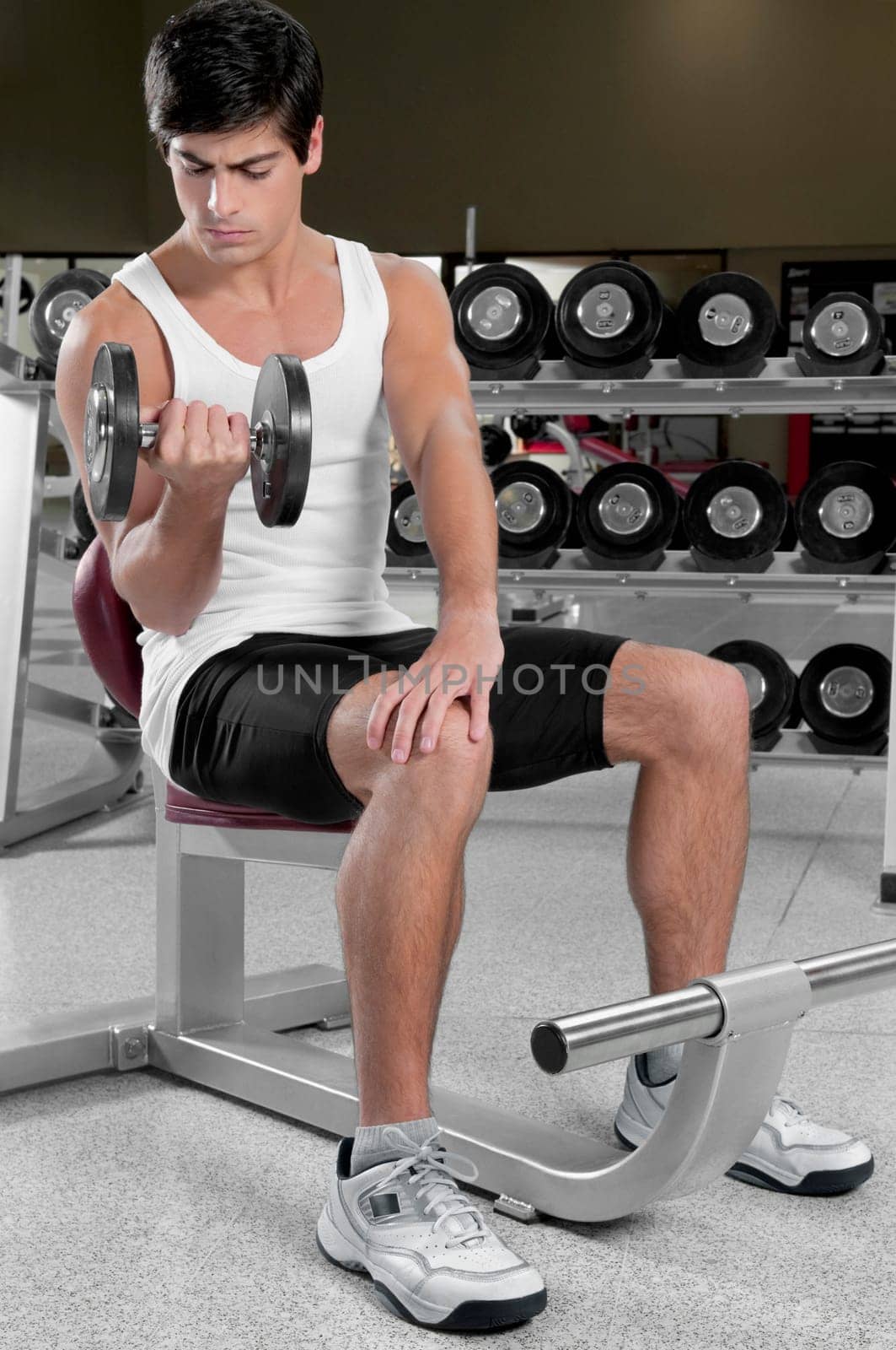 Man exercising with dumbbells in a gym