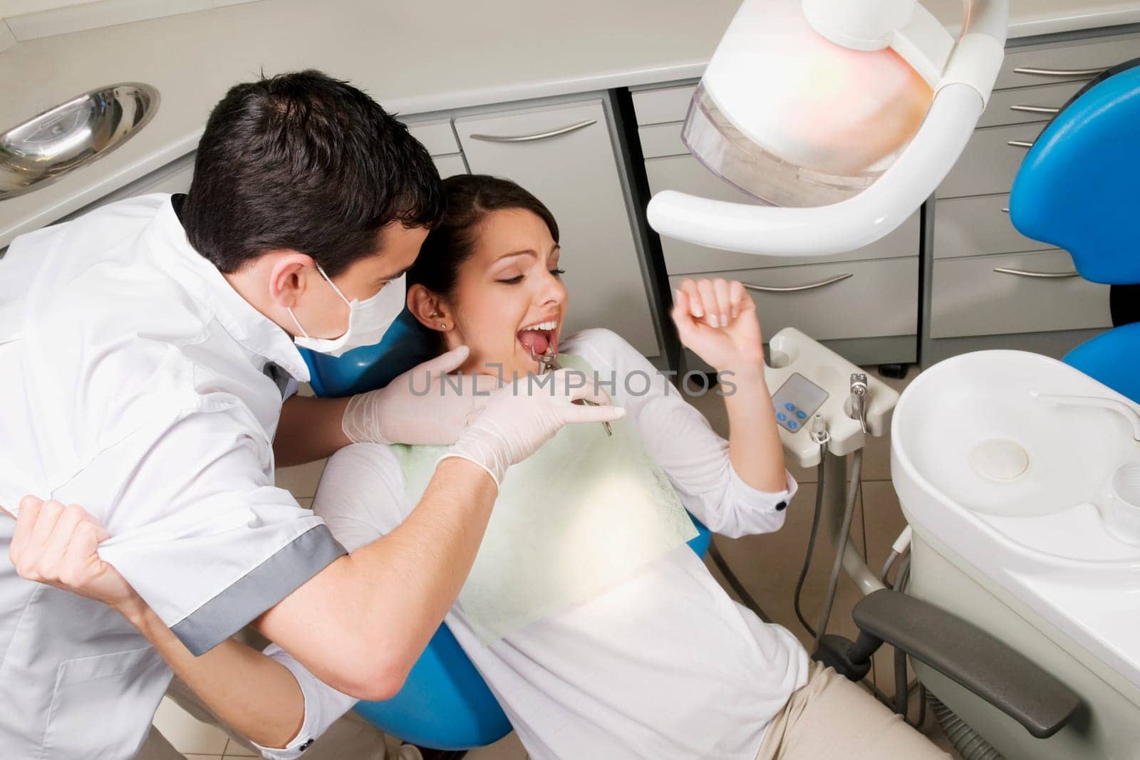 Dentist using pliers to pull out womanŽs teeth