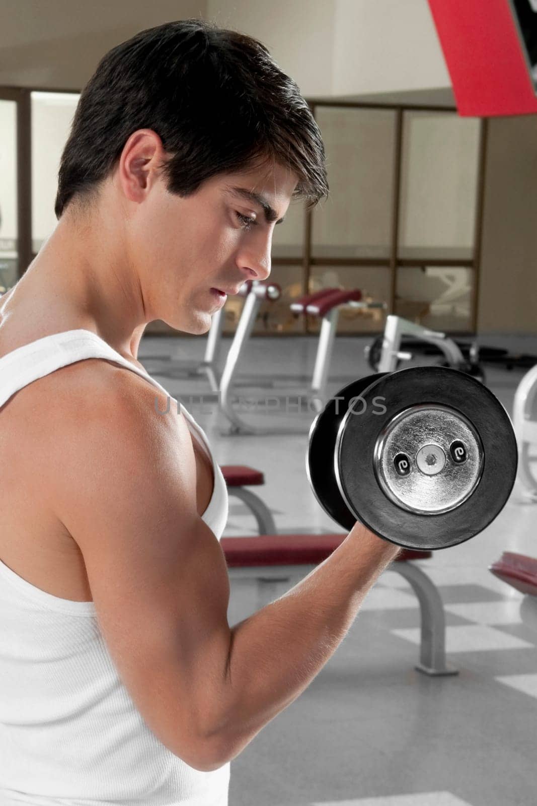 Man exercising with dumbbells in a gym