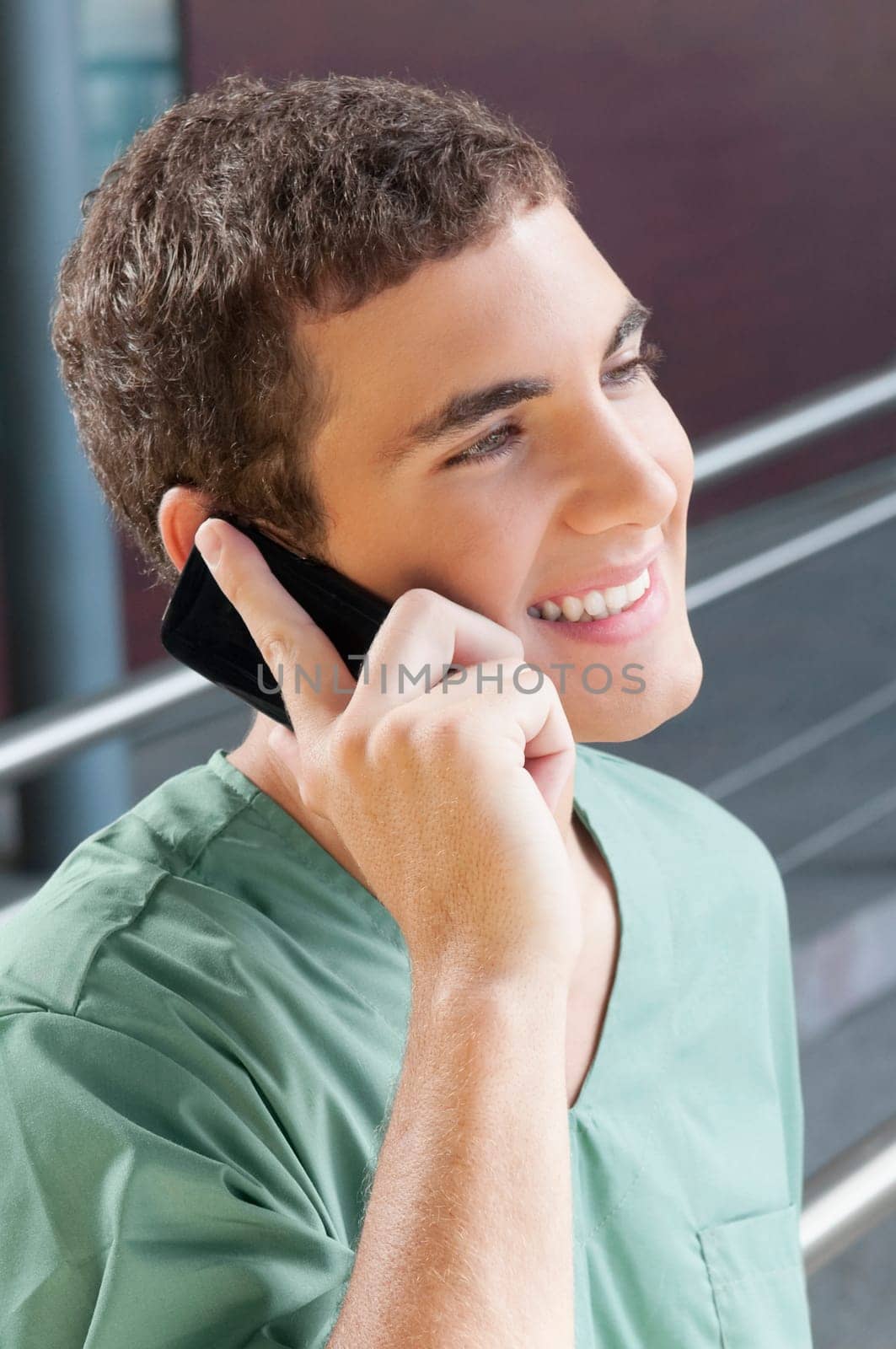 Male nurse talking on a mobile phone and smiling