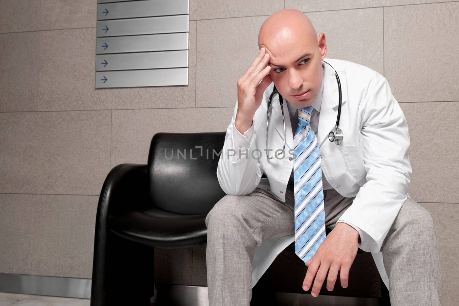 Doctor sitting on a chair and looking stressed
