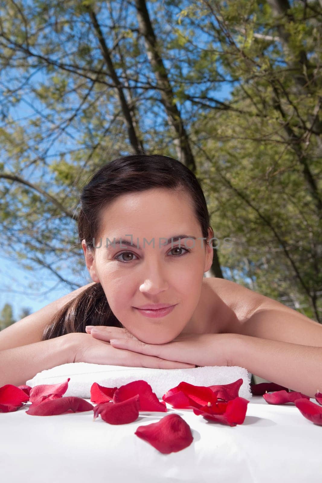 Portrait of a woman lying on a massage table with rose petals
