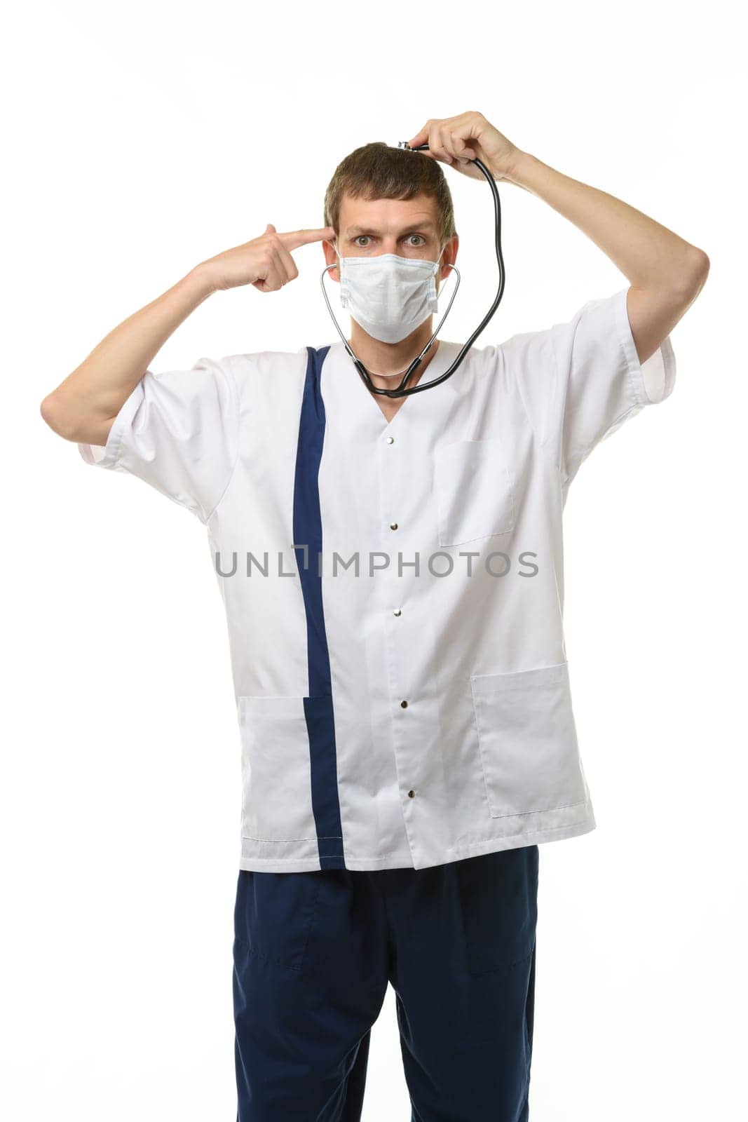 A masked doctor with a phonendoscope listens to his head, with the other hand he applied an impromptu pistol to his temple, isolated on a white background