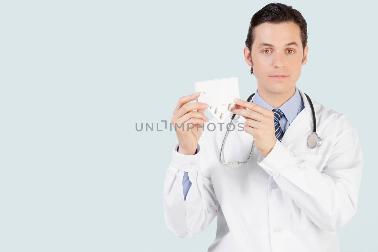 Portrait of a doctor holding a medicine pack