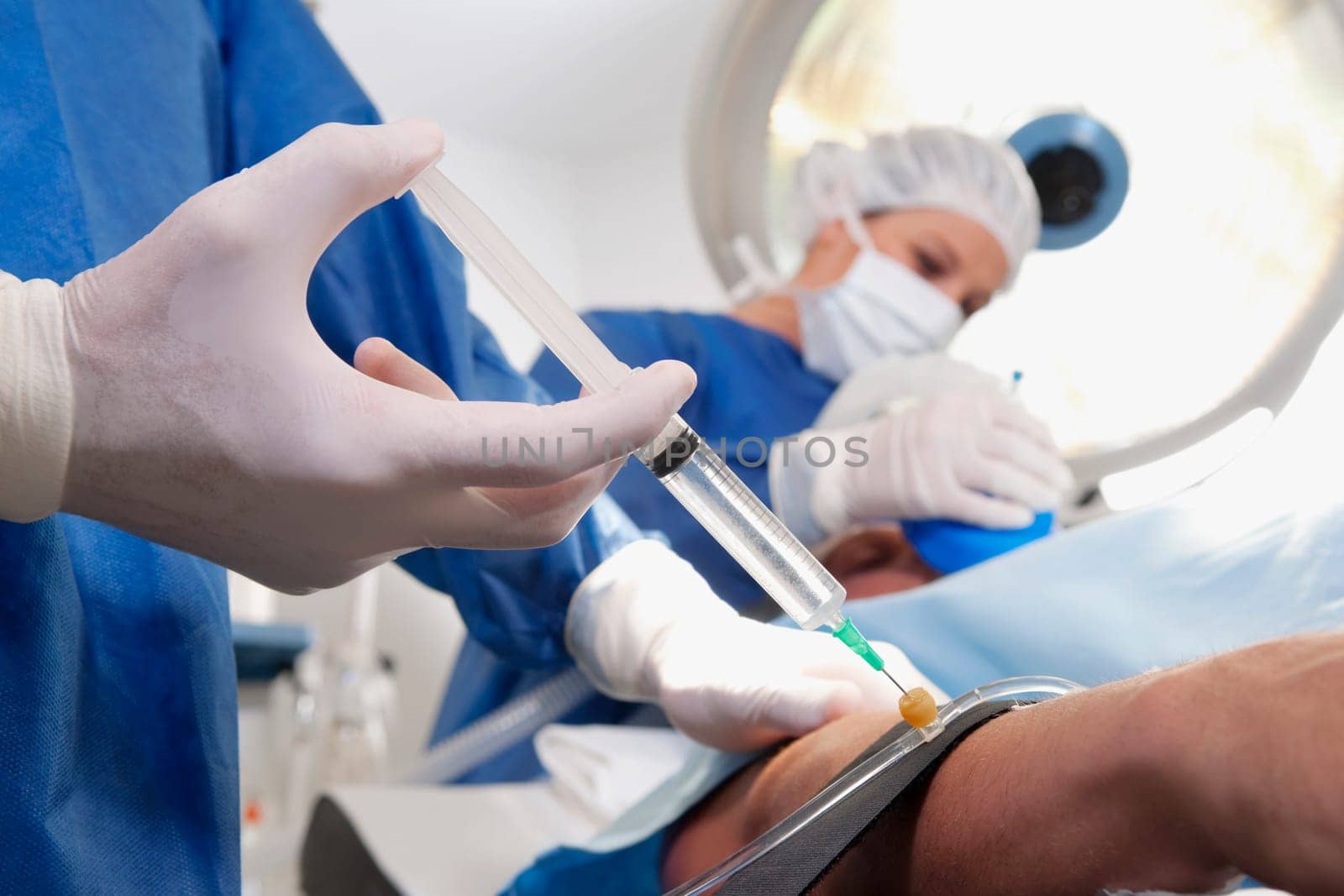 Doctor injecting patientŽs arm in an operating room