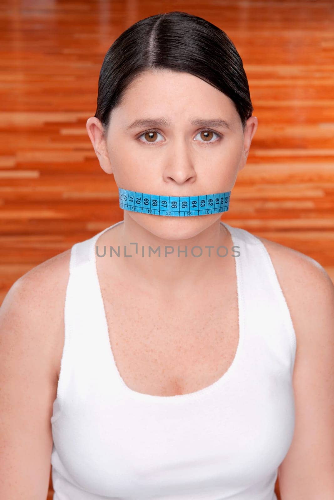 Woman covering her mouth with a tape measure