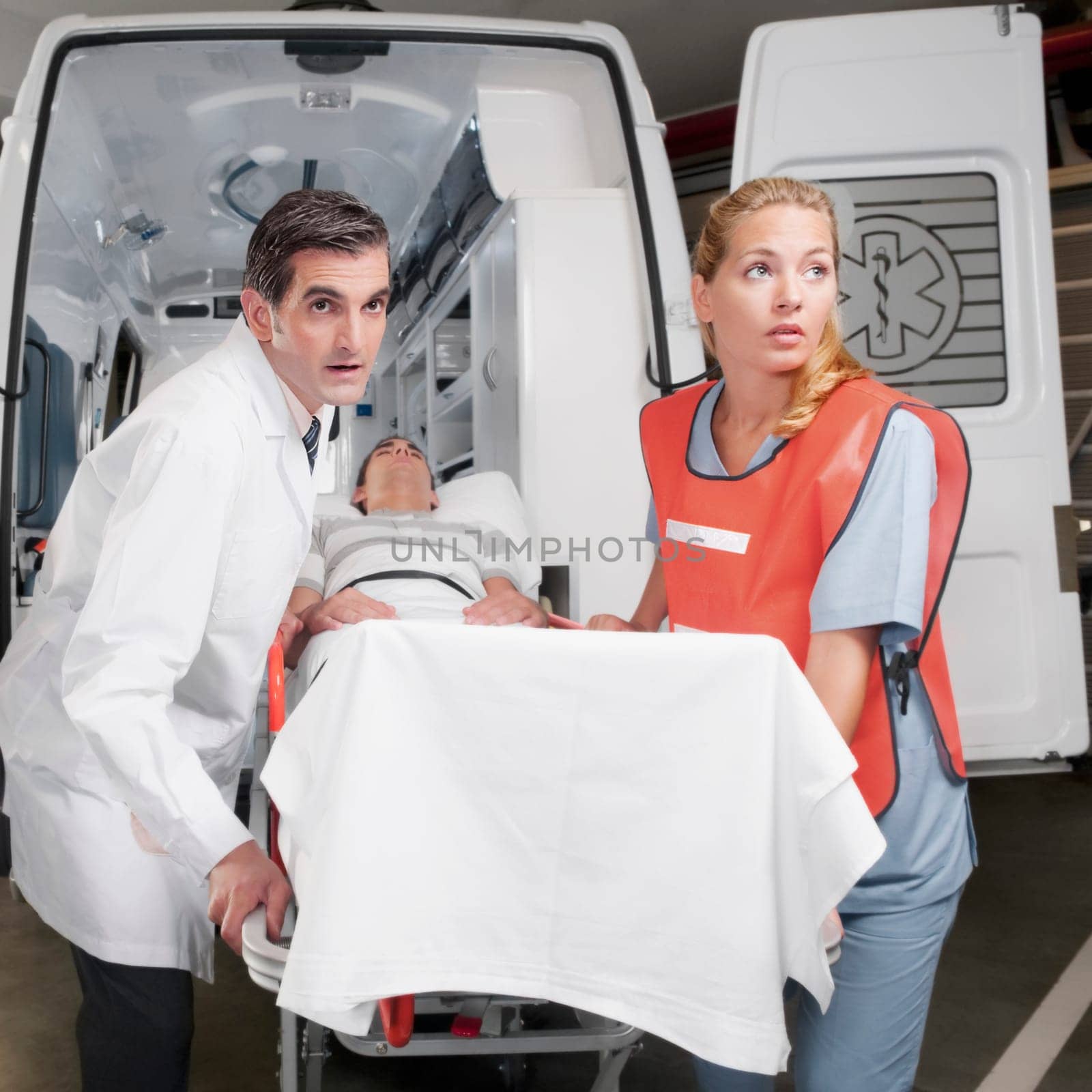 Paramedics leading a patient on a gurney from an ambulance