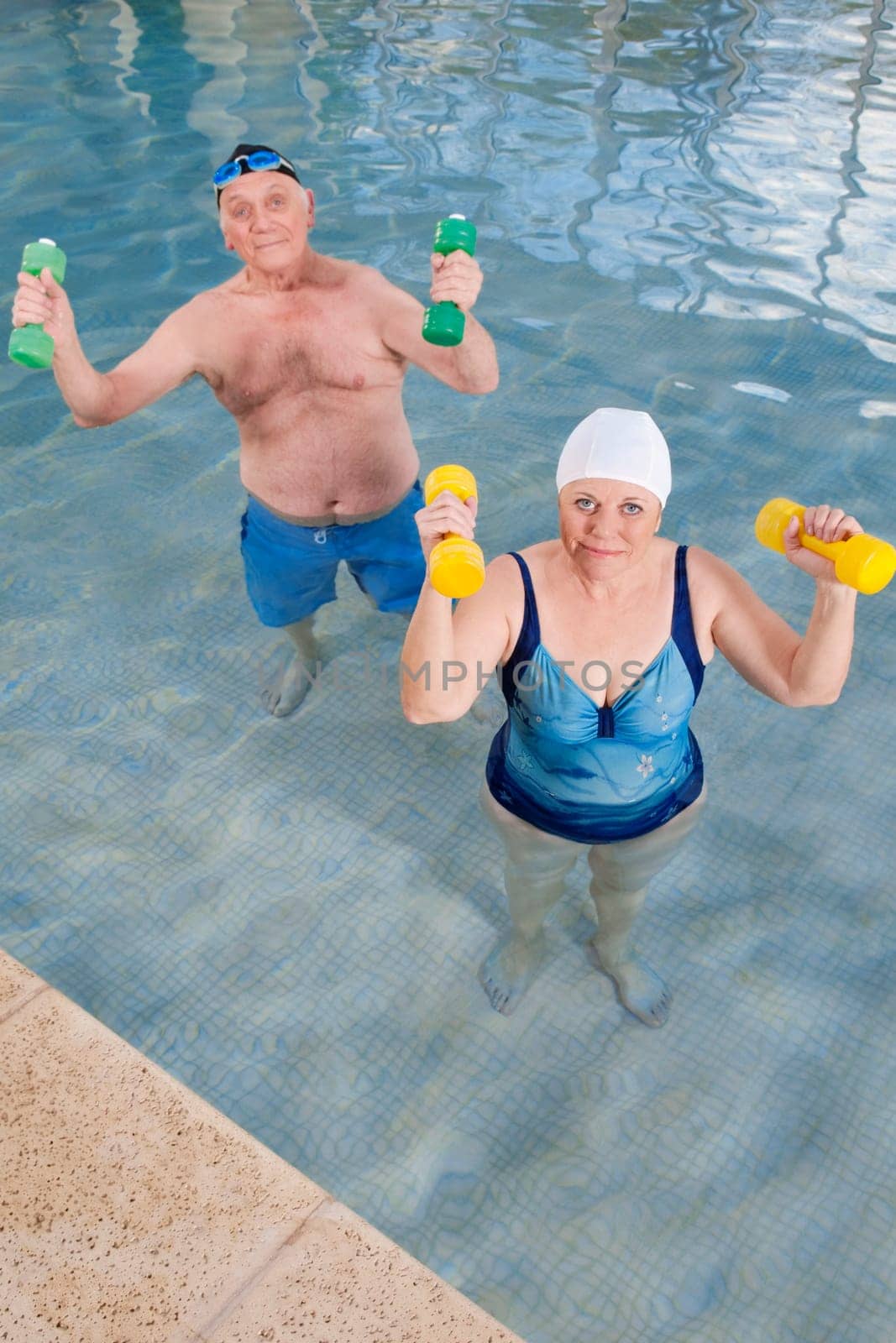 Couple exercising with dumbbells in a swimming pool