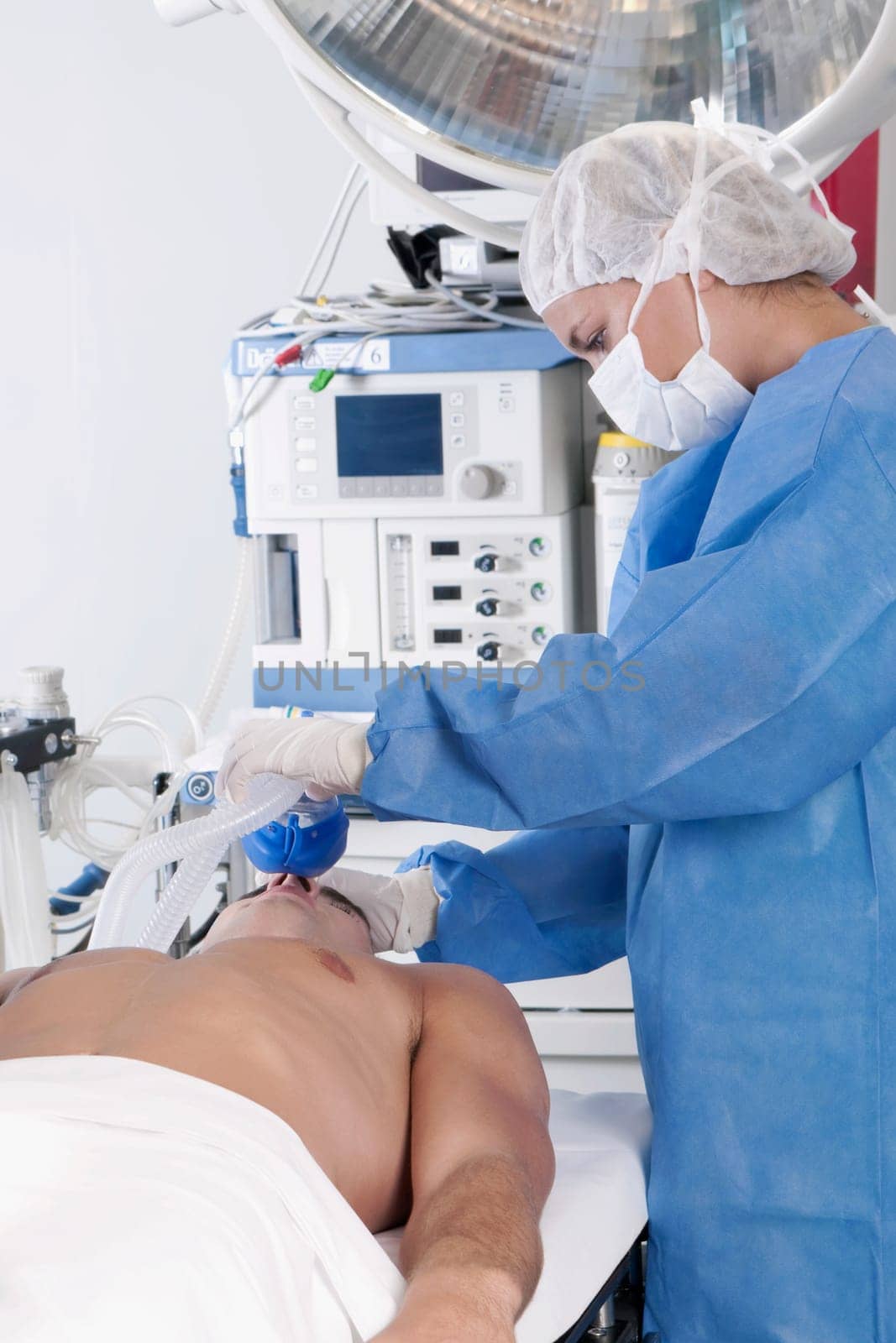 Female surgeon anesthetizing a patient in an operating room