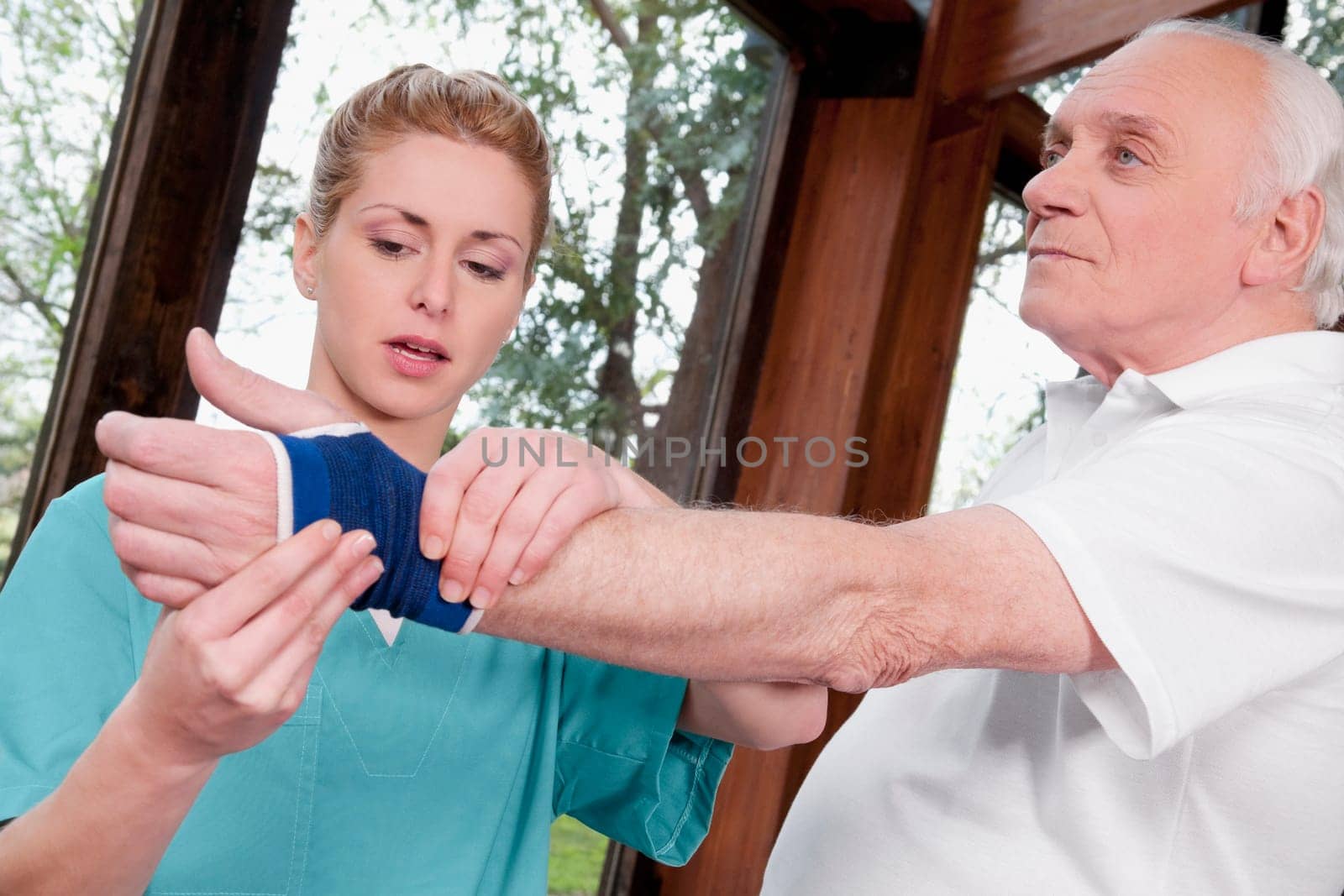 Health worker putting on a wrist brace to a disabled man