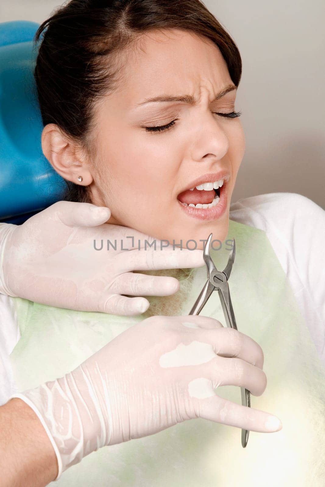 Dentist using pliers to pull out womanŽs teeth