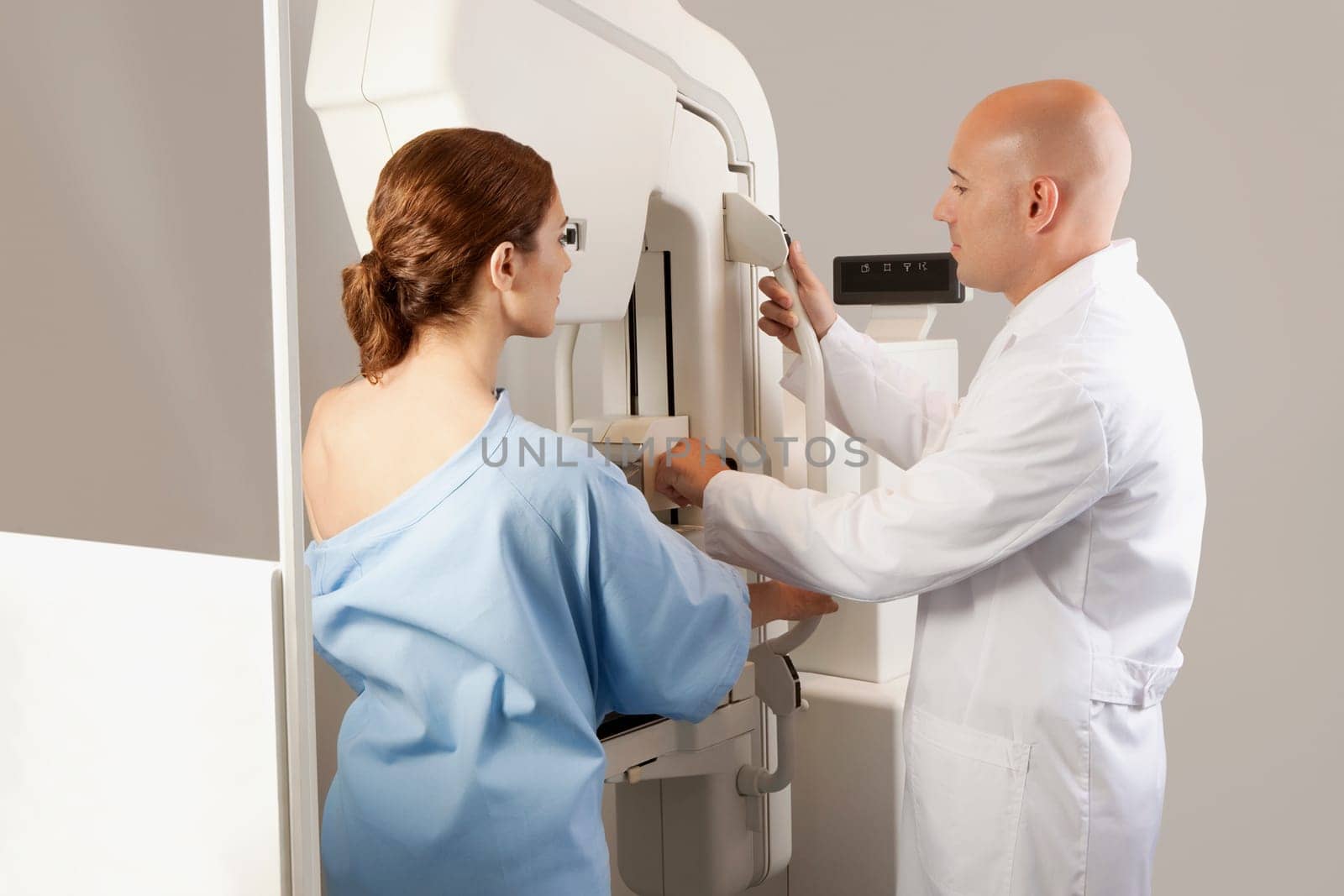 Doctor assisting a female patient for mammogram