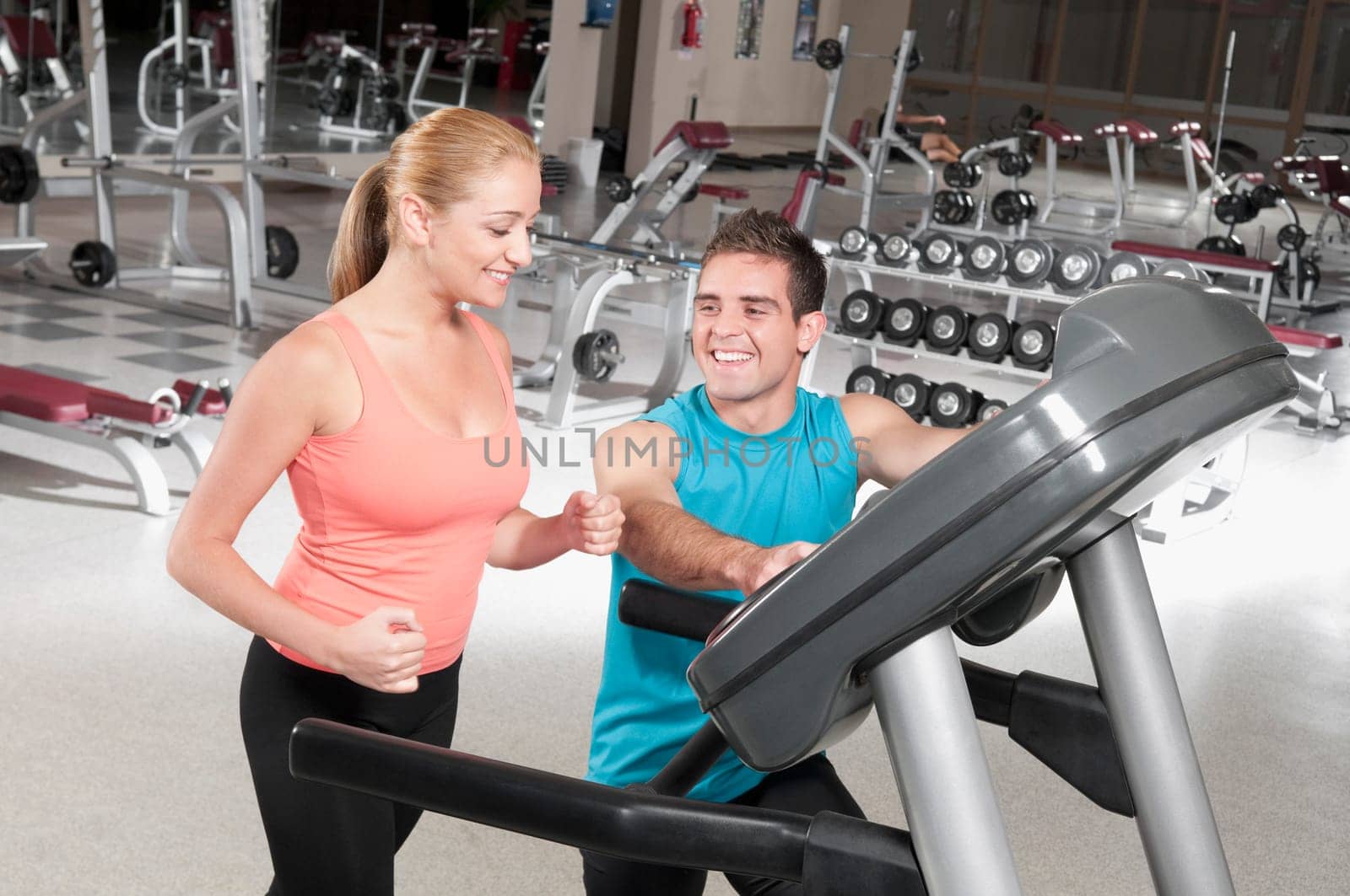 Man assisting a woman on a treadmill