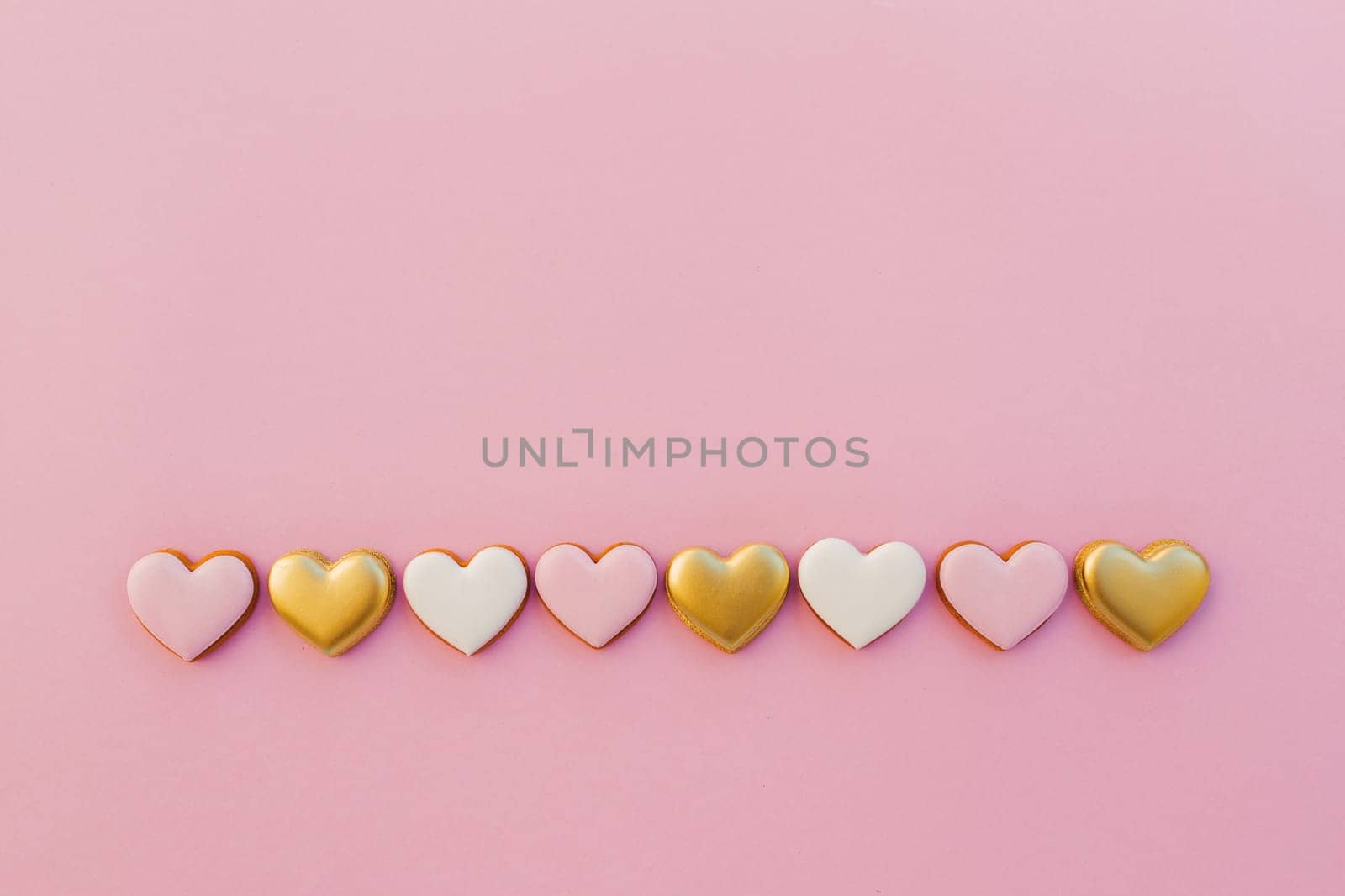 Pink background with sweet gingerbread heart cookies. High quality photo