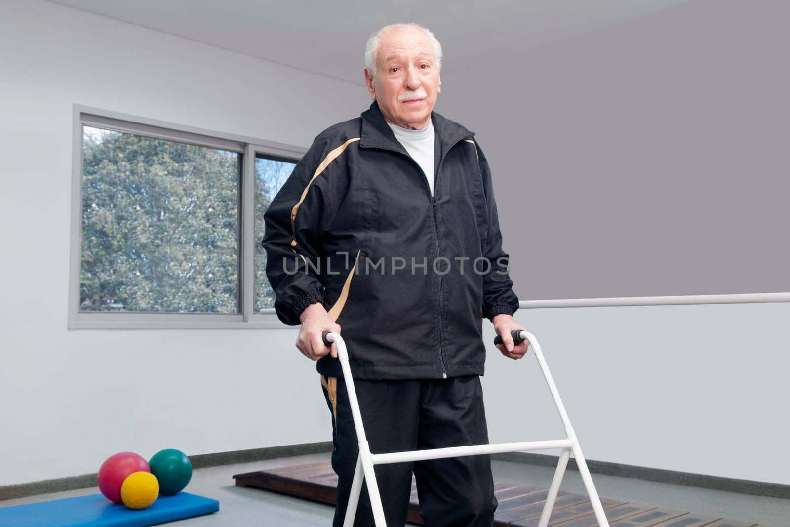 Portrait of a disabled man walking with a walker