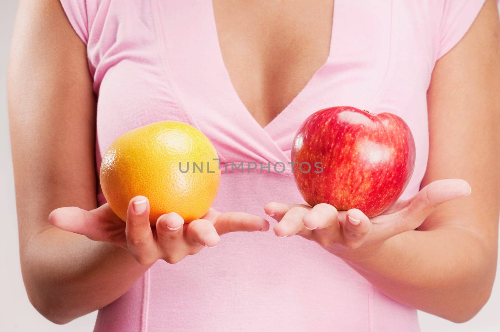 Woman holding an apple and an orange