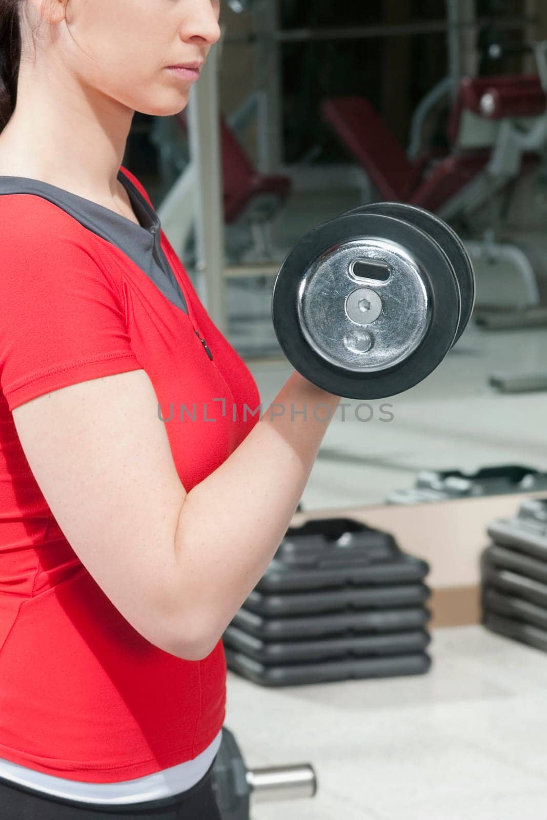 Woman exercising with dumbbells in a gym