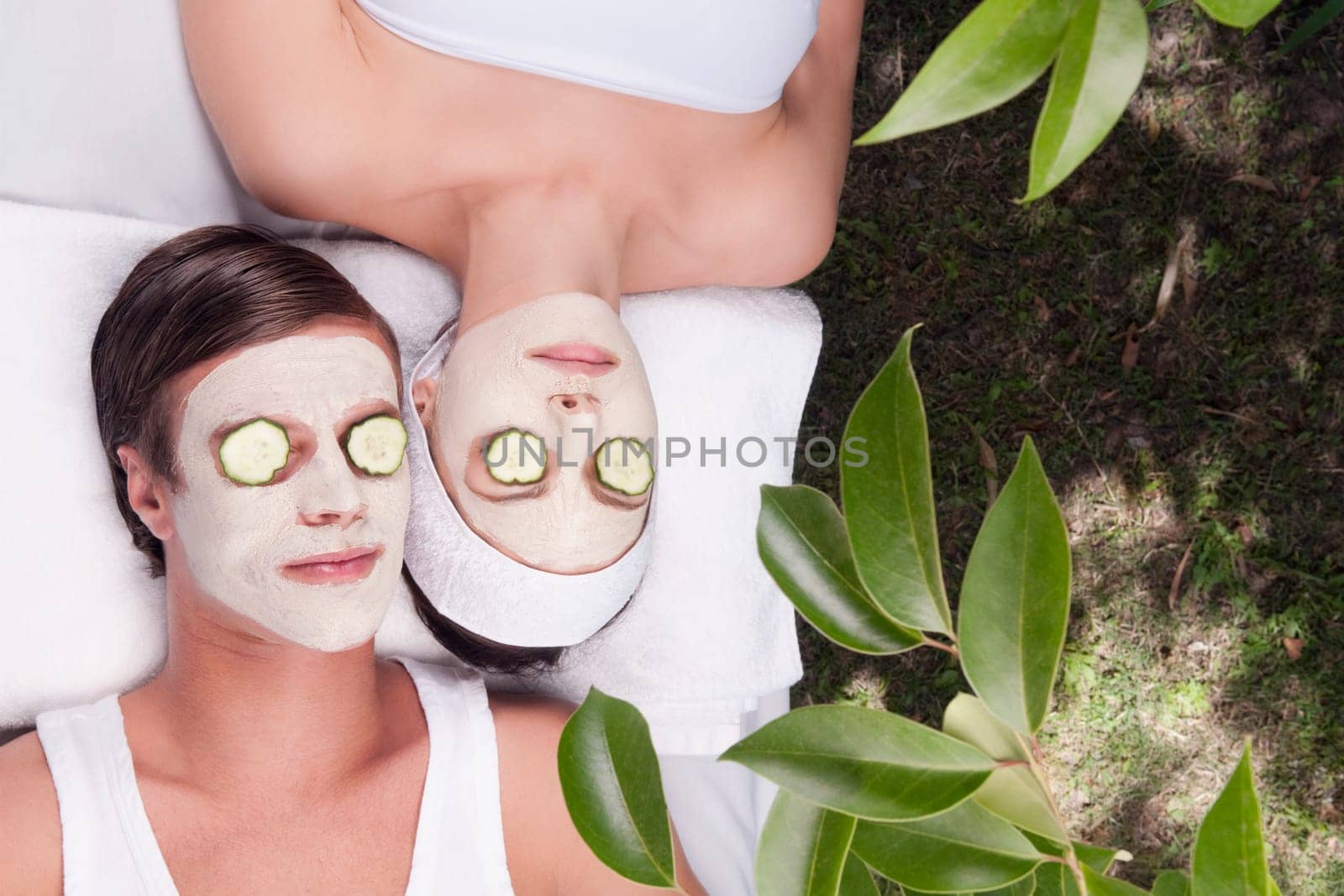 Couple with face pack and cucumber slices on their eyes