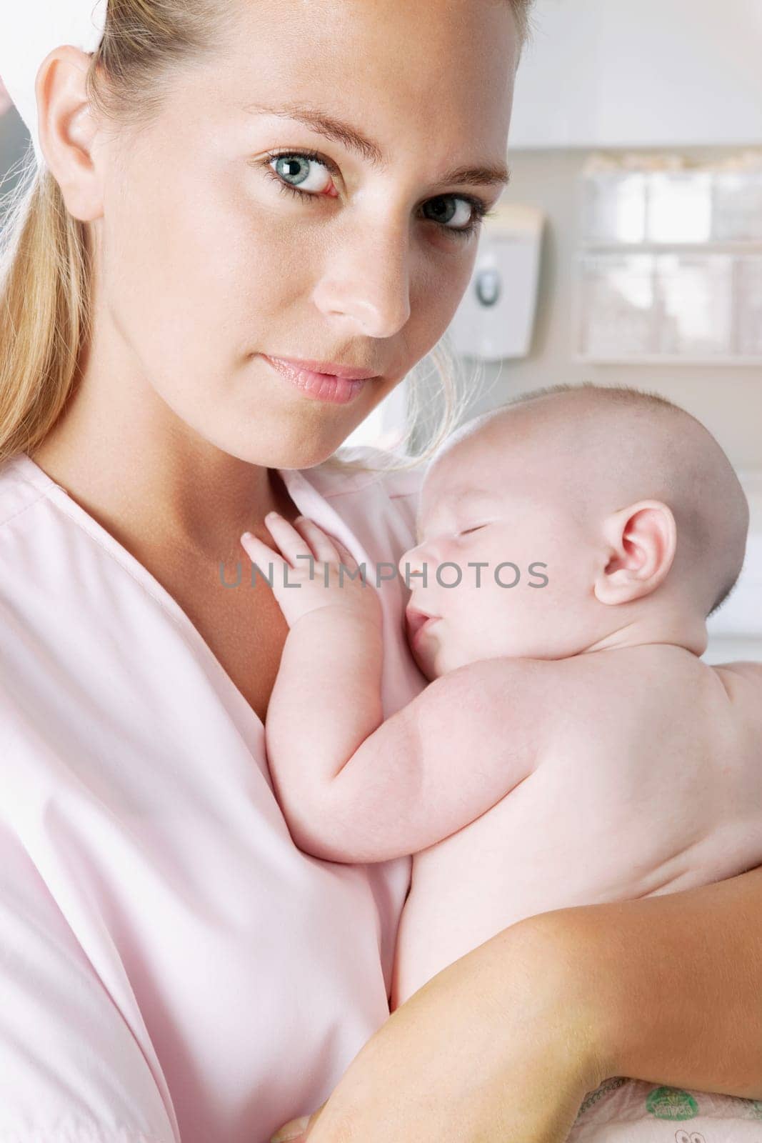 Female nurse carrying a newborn baby