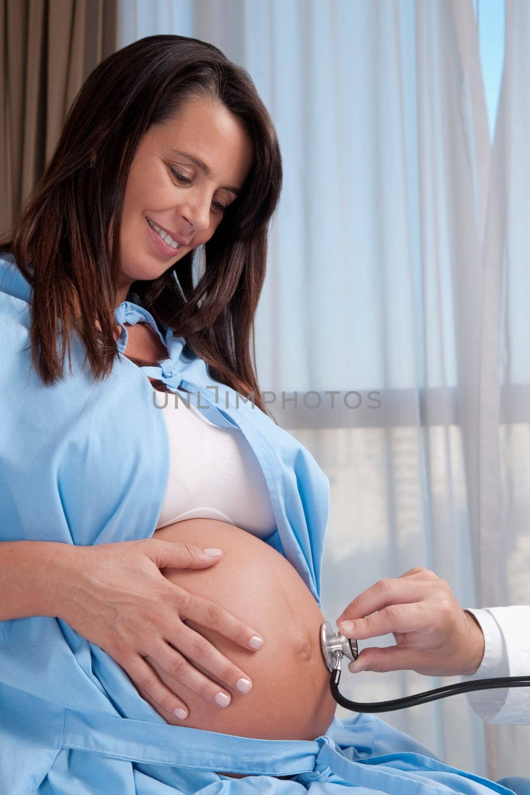 Doctor examining a pregnant woman with a stethoscope