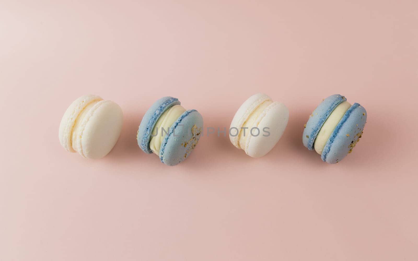 White and blue macaroons on the table, macaroons on pink background. High quality photo