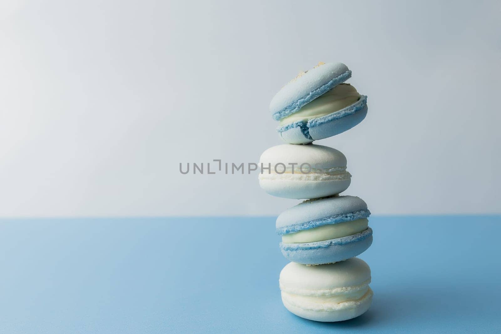 White and blue macaroons on the table, macaroons on blue background. High quality photo