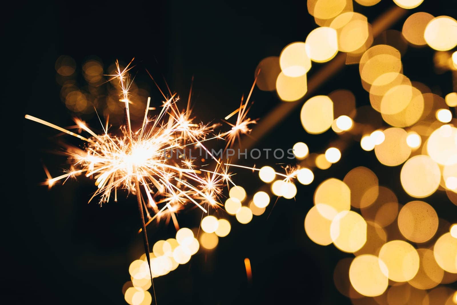 Sparklers on blurred christmas lights. Festive mood. High quality photo